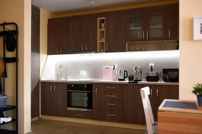 a kitchen with wooden cabinets and a sink and stove at Sandy Dreams Cozy Studio in Pomorie