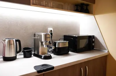 a kitchen counter with two coffee makers and a microwave at Sandy Dreams Cozy Studio in Pomorie