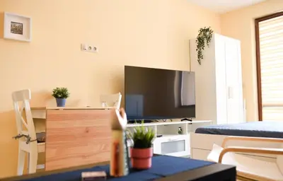 a living room with a tv and a table at Sandy Dreams Cozy Studio in Pomorie
