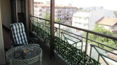 a balcony with a chair and a glass table at Gnezdo Apartment Sarafovo in Burgas City