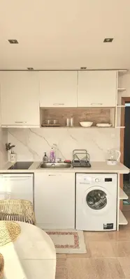 a white kitchen with a washing machine in it at The Boho House with Free Parking in Nesebar