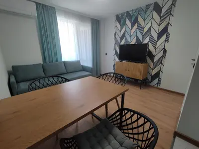 a living room with a couch and a table and chairs at RadiSun with Free Parking space in Burgas City