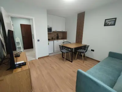 a living room with a couch and a table and a kitchen at RadiSun with Free Parking space in Burgas City