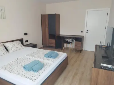 a bedroom with a bed with two blue towels on it at RadiSun with Free Parking space in Burgas City