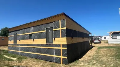 a black and wooden building in a yard at Бунгало woodwave in Chernomorets