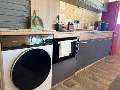 a kitchen with a washing machine on a counter at Бунгало woodwave in Chernomorets