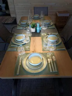a wooden table with plates and wine glasses on it at Бунгало woodwave in Chernomorets