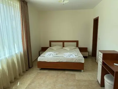 a bedroom with a bed and a desk and a window at Ravda14 in Ravda