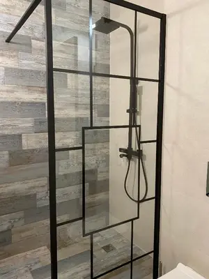 a glass shower in a bathroom with a wooden wall at Coastal home Arapya in Tsarevo