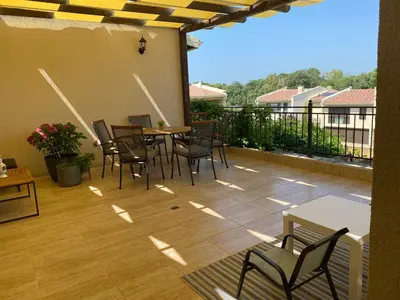 a patio with a table and chairs on a balcony at Coastal home Arapya in Tsarevo