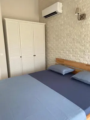 a bedroom with a blue bed and a brick wall at Coastal home Arapya in Tsarevo