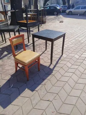 a chair and a table on a brick sidewalk at Small City Studio in Varna City