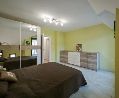 a bedroom with a large bed and a large mirror at Уютная квартира рядом с центром Бургаса in Burgas City