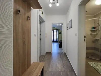 a hallway with white walls and a wooden table at Уютная квартира рядом с центром Бургаса in Burgas City