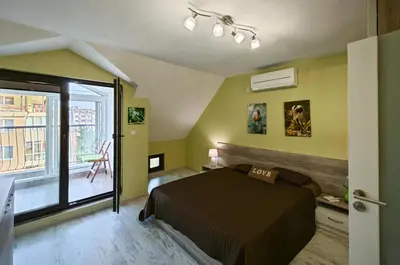 a bedroom with a bed and a large window at Уютная квартира рядом с центром Бургаса in Burgas City