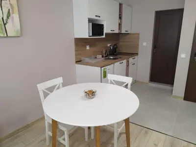 a white kitchen with a white table and chairs at BoriSun with Free Parking space in Burgas City