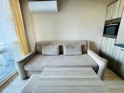 a couch with two pillows sitting in a room at PARADISO B 411 Large SEA VIEW Studio Nessebar in Nesebar