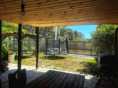 a screened in porch with a hammock in the yard at Боровата къща in Varna City