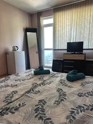 a bedroom with a large bed with two pillows on it at Боровата къща in Varna City