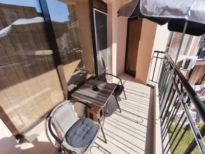 a balcony with a bench and a table and an umbrella at Apartment 15 Sea Grace in Sunny Beach
