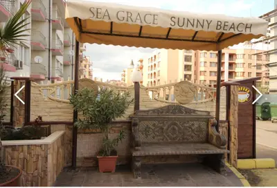 a bench under a gazebo on a city street at Apartment 15 Sea Grace in Sunny Beach