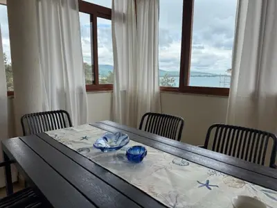 a dining room table with chairs and a table with blue dishes at Апартамент Созополски Залез in Sozopol