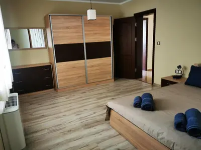 a bedroom with a large closet with blue pillows on a bed at Апартамент Созополски Залез in Sozopol