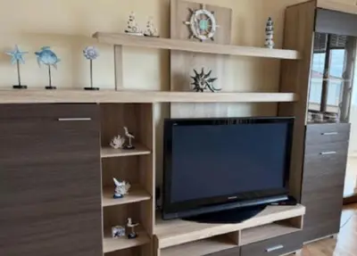 a living room with a television in a entertainment center at Апартамент Созополски Залез in Sozopol