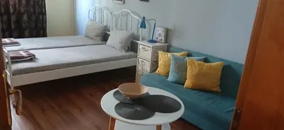 a room with a couch and a table with a hat on it at Стая за двама в град Бургас in Burgas City