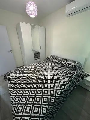 a bedroom with a bed with a black and white comforter at Морски Бриз in Lozenets