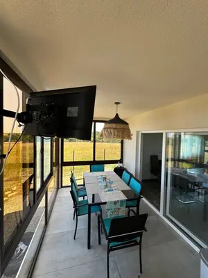 a dining room with a table and chairs on a balcony at Морски Бриз in Lozenets