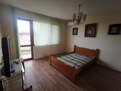 a bedroom with a bed and a tv and a window at Affordable Rooms with BBQ 5 min drive from beach Villa Lusi in Varna City