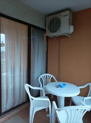 a room with a table and chairs and a fan at Марина Кеѝп, Ахелой in Aheloy