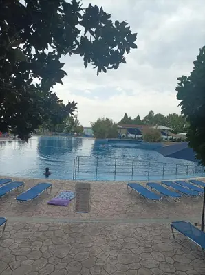a swimming pool with chairs and a sign in front of it at Марина Кеѝп, Ахелой in Aheloy