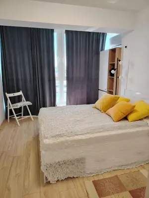 a bedroom with a large bed with yellow pillows at Level 5 in Burgas City