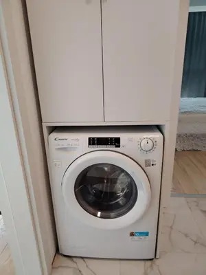 a washing machine with a white cabinet above it at Level 5 in Burgas City
