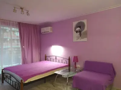 a purple bedroom with a bed and a table at Parus 4 Studio in Pomorie