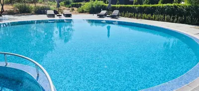 a large swimming pool with blue water and chairs at JADORE DUNE Apartment 9 Sunny Beach in Sunny Beach
