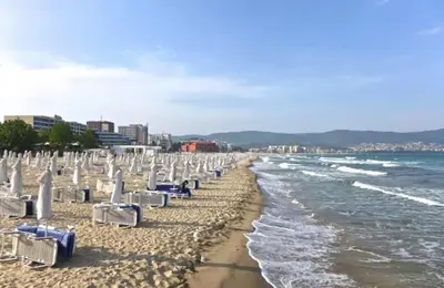 a beach with lounge chairs and the ocean at JADORE DUNE Apartment 9 Sunny Beach in Sunny Beach