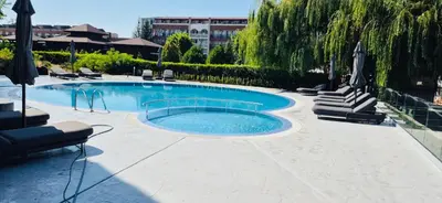 a large swimming pool with lounge chairs and umbrellas at JADORE DUNE Apartment 10 Sunny Beach in Sunny Beach