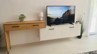 a flat screen tv on a dresser in a living room at JADORE DUNE Apartment 10 Sunny Beach in Sunny Beach