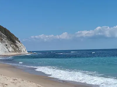 a beach with the ocean and mountains in the background at Sunny Byala in Byala