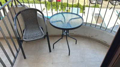 a table and a chair sitting on a balcony at Jolka in Sunny Beach