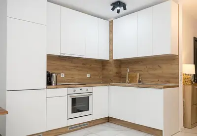 a kitchen with white cabinets and wooden walls at BuenaVista I Modern Comfort near Varna City Center by Flat Mаnаger in Varna City