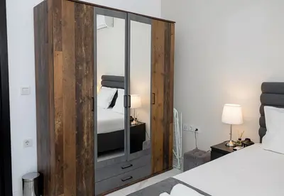 a bedroom with a wooden cabinet with a mirror at BuenaVista I Modern Comfort near Varna City Center by Flat Mаnаger in Varna City