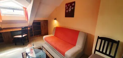 a living room with an orange couch and a table at Top Floor Two Bedroom Apartment in Central Burgas in Burgas City