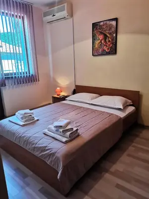 a bedroom with a large bed with towels on it at Guest House Bа́kish Obzor in Obzor