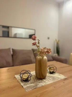 a vase with flowers in it sitting on a table at Detelina Apartment Bee Happy in Burgas in Burgas City
