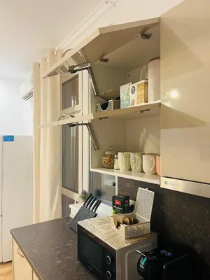 a kitchen with white cabinets and a counter top at Detelina Apartment Bee Happy in Burgas in Burgas City
