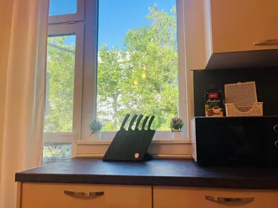 a kitchen with a counter with two knives in front of a window at Detelina Apartment Bee Happy in Burgas in Burgas City